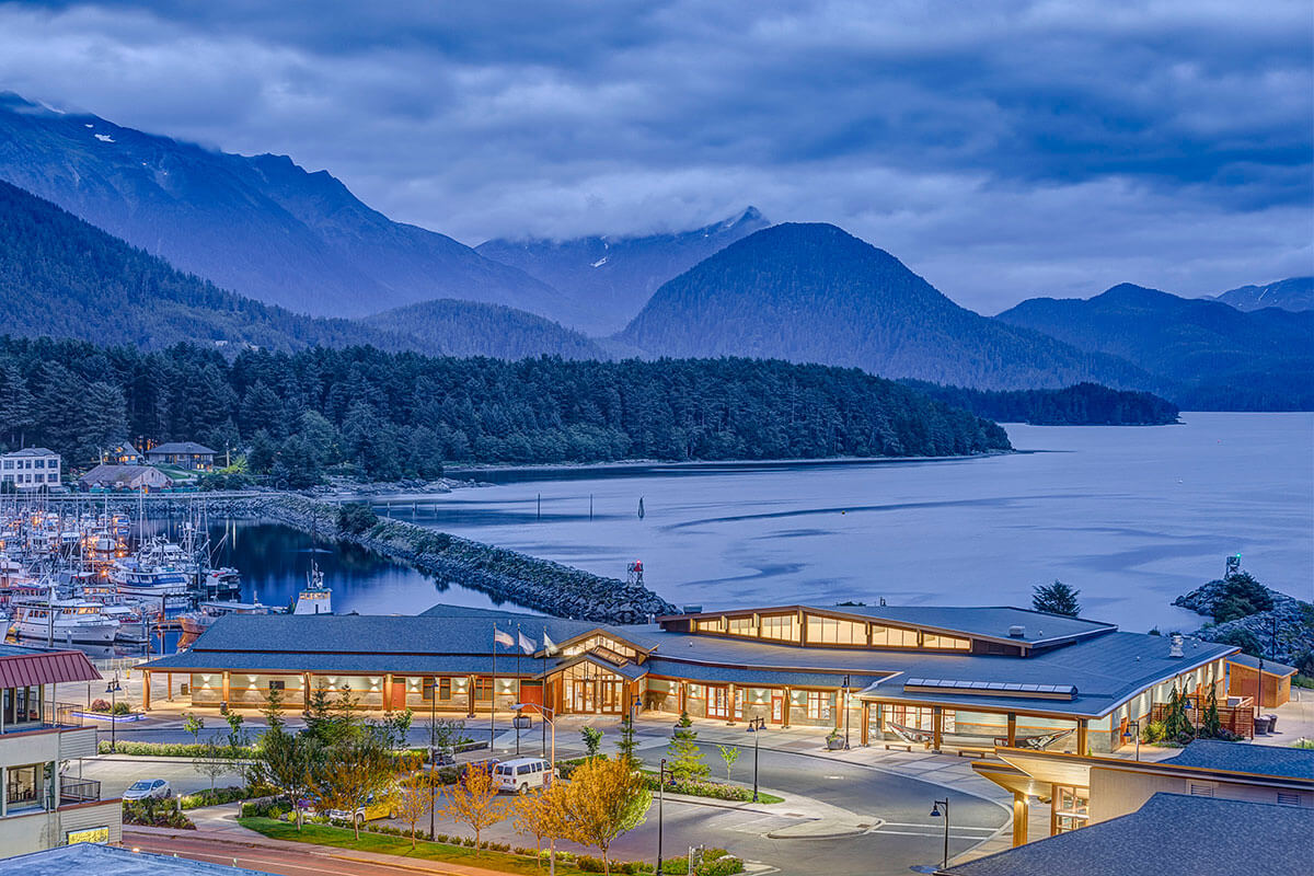 Exterior view of the Harrigan Centennial Hall with mountains of Sitka behind.